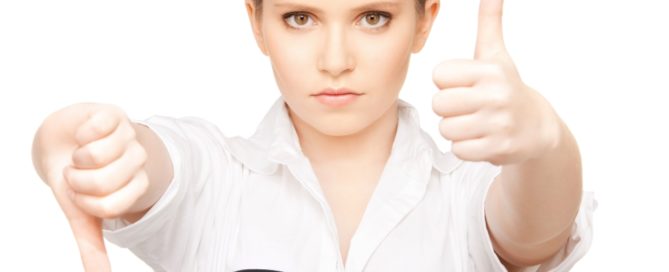A professional woman holding one thumb up and one thumb down