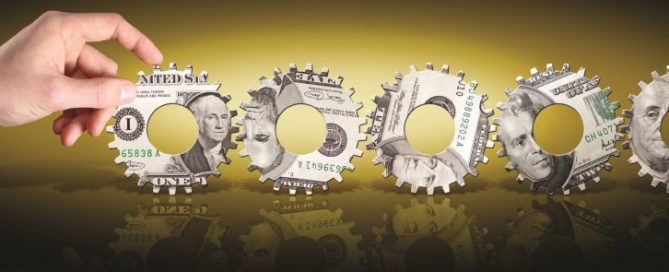 A hand turning gears made of dollar bills