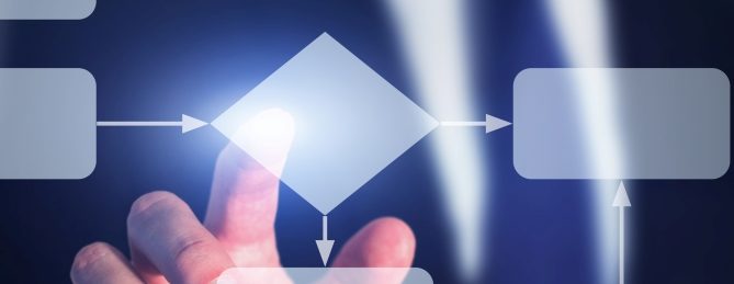 A man in a suit using his finger to touch a box on a digital representation of a workflow
